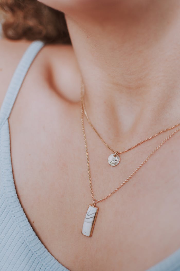 Home Close-up of a woman's neck showcasing elegant gold necklaces and minimalist fashion.