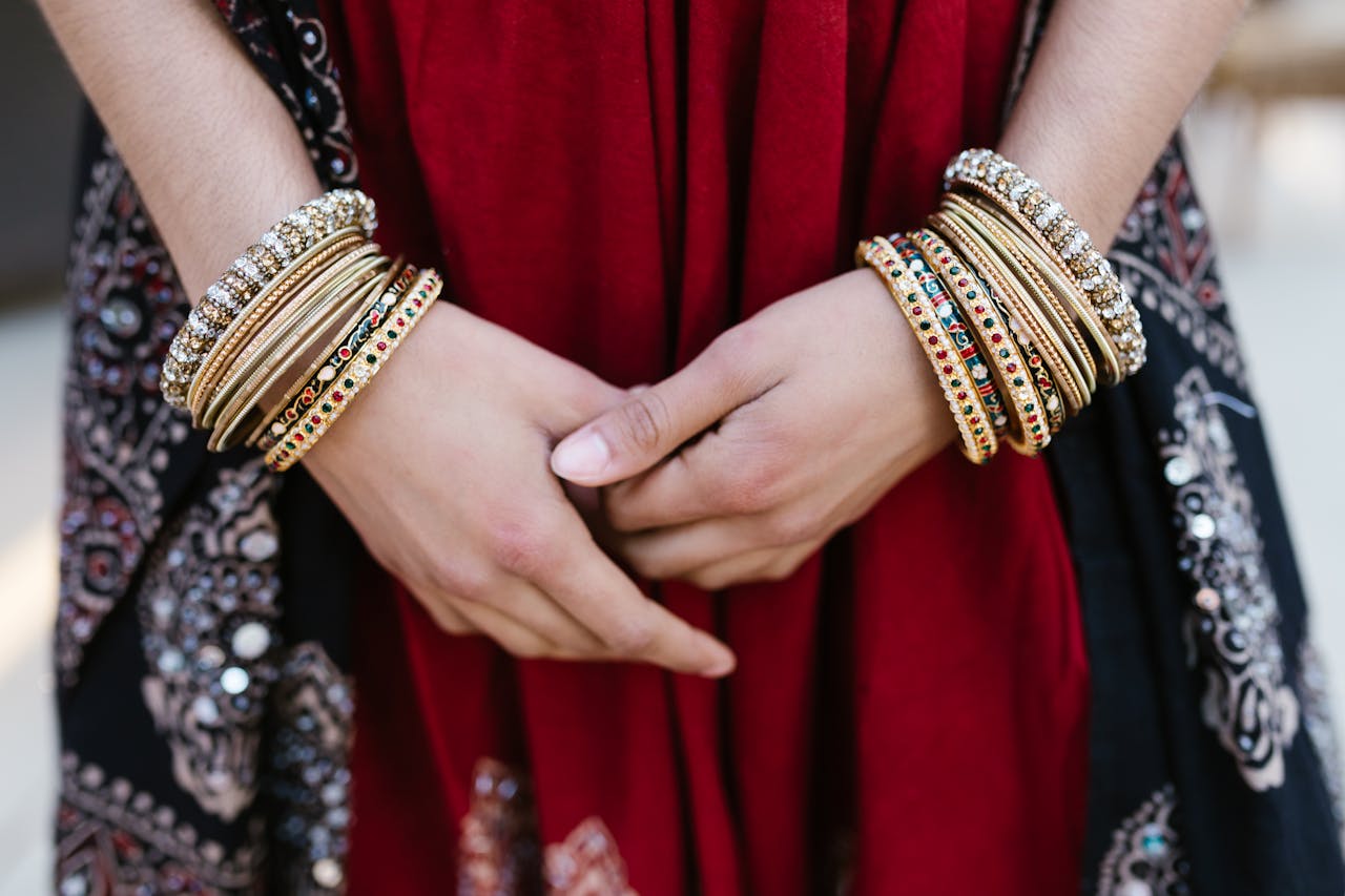 Home Close-up of a woman's hands adorned with colorful traditional bangles, showcasing cultural attire.